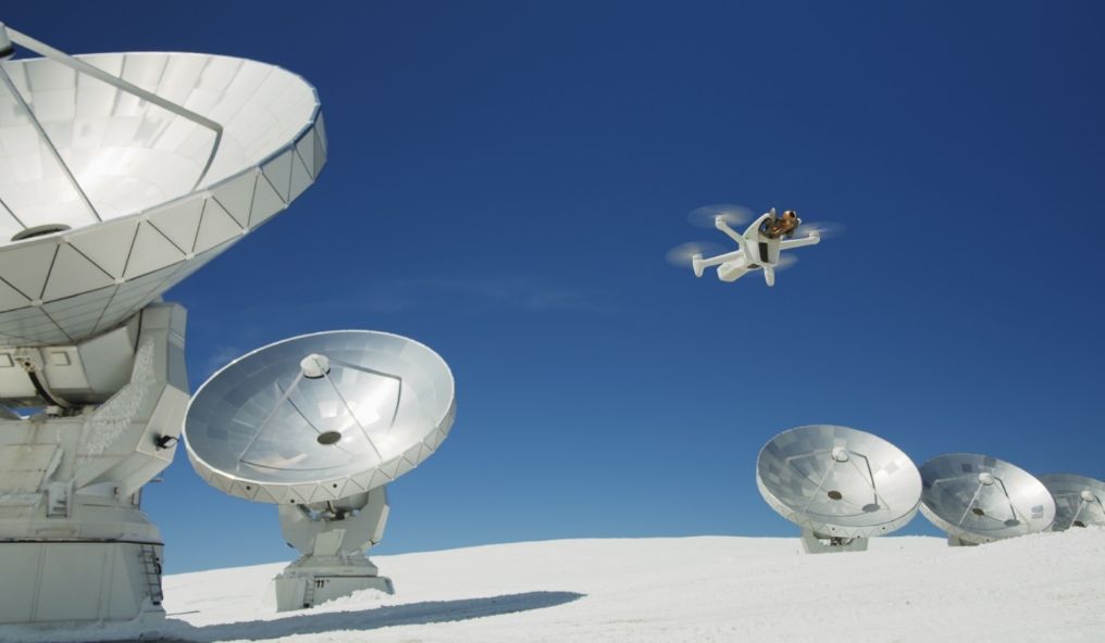 Drone flying over a snowy landscape with radio telescopes
