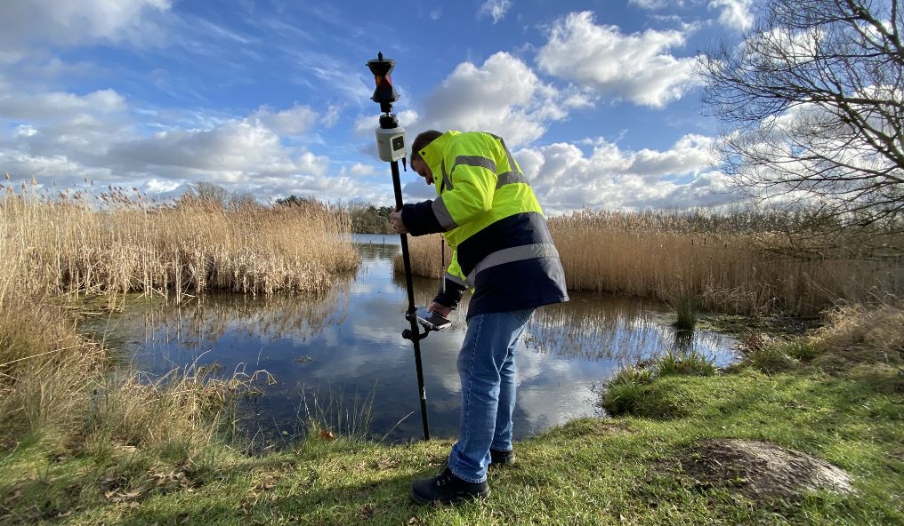 Surveyor mappign precise location data for a river