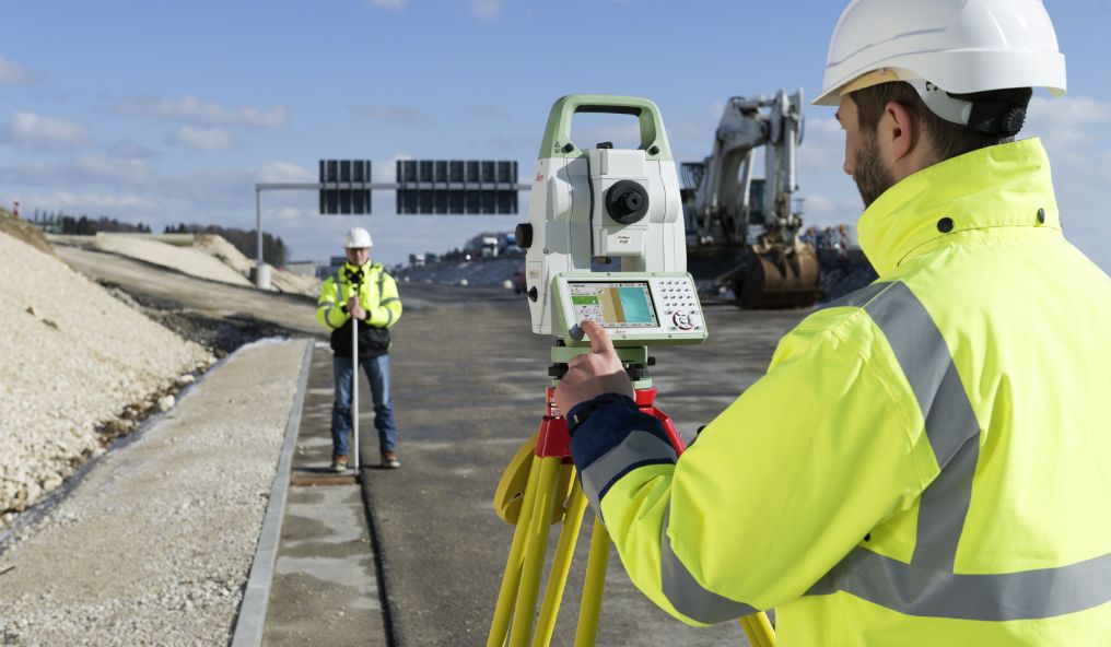 Image shows to surveyors setting points on a motorway work site
